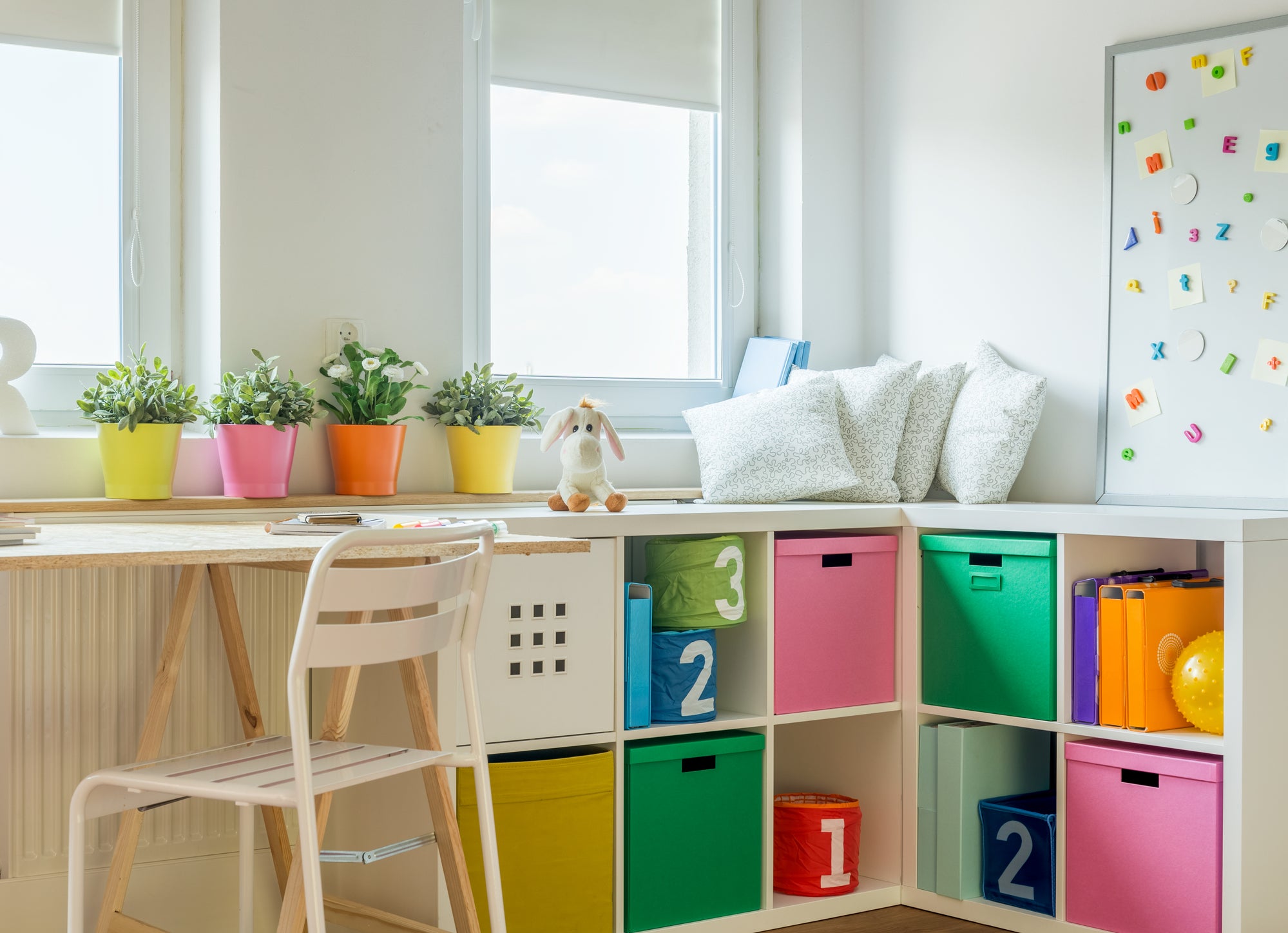 Kids desk with plants on it and storage area in bright colors